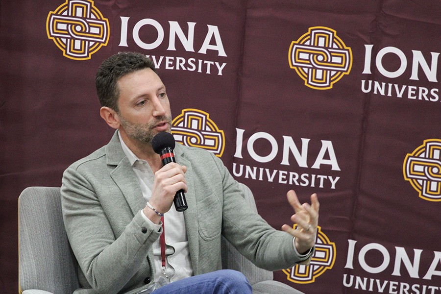 Matthew Caiola speaking into a microphone at Iona Scholars Day in April 2025