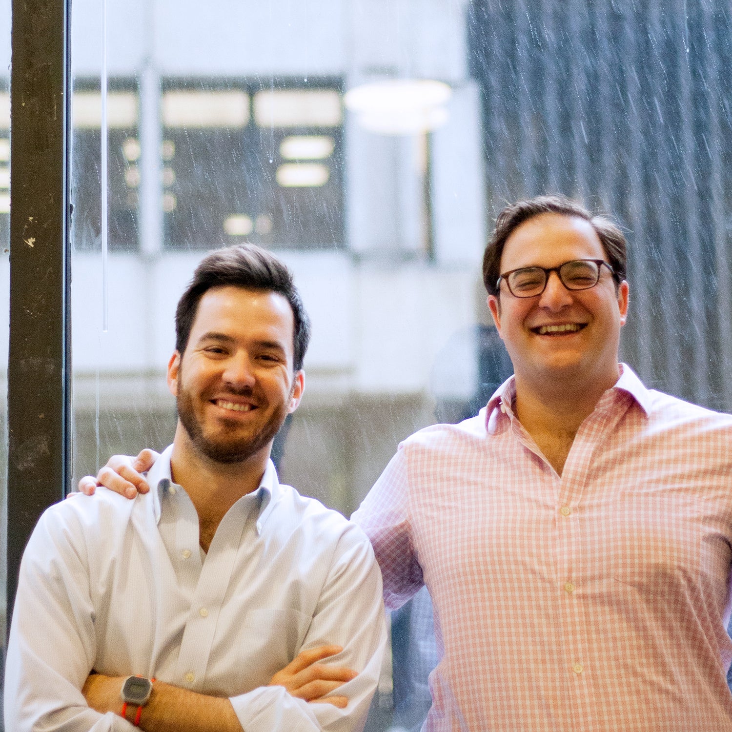 Matt Harrigan on the left and Charlie Bonello standing together by a window