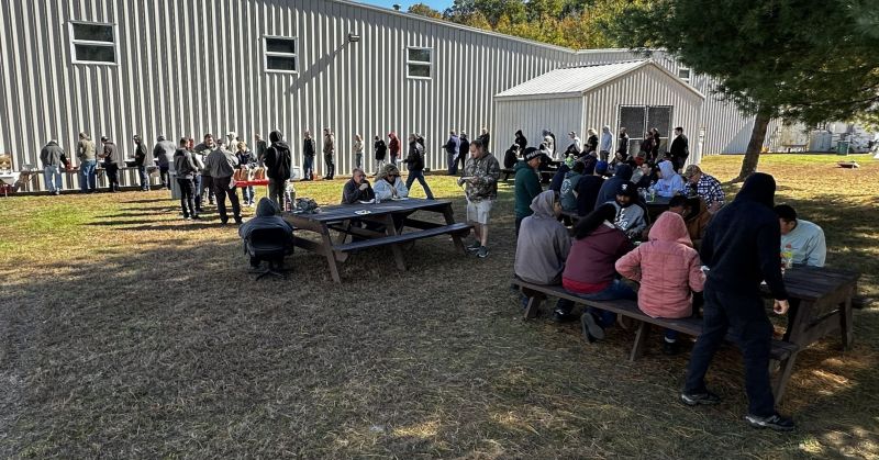 Columbia Manufacturing employees gathered at picnic tables outside the factory