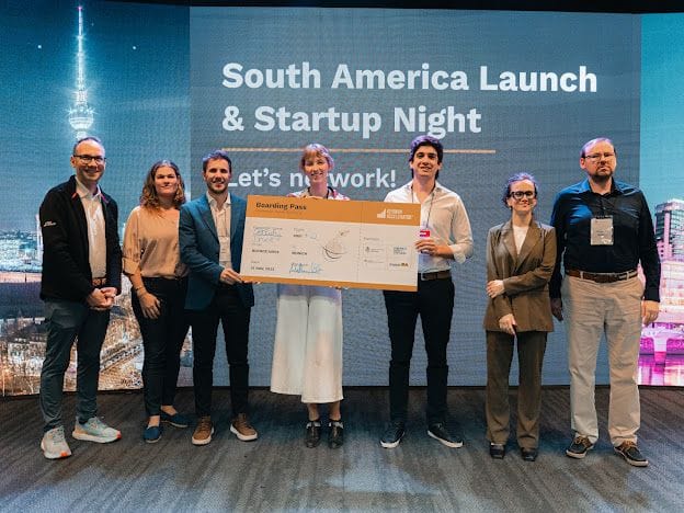 Matthias Notz at far left with founders and judges beside an oversized boarding pass at the South America launch