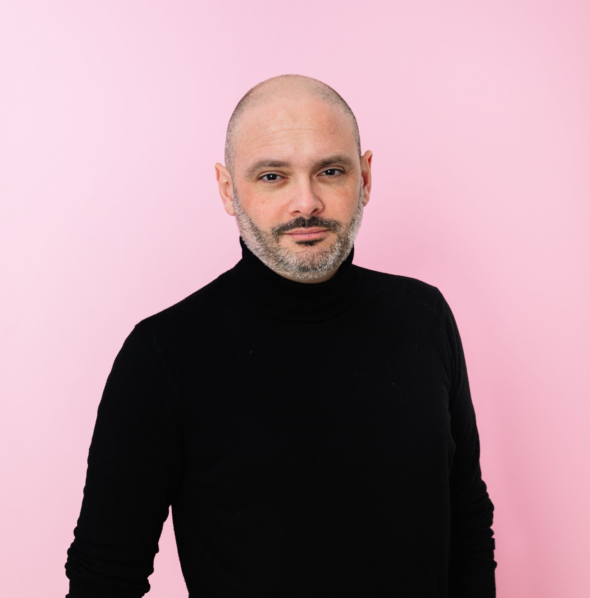Matyas Gabor in a black turtleneck against a pink background