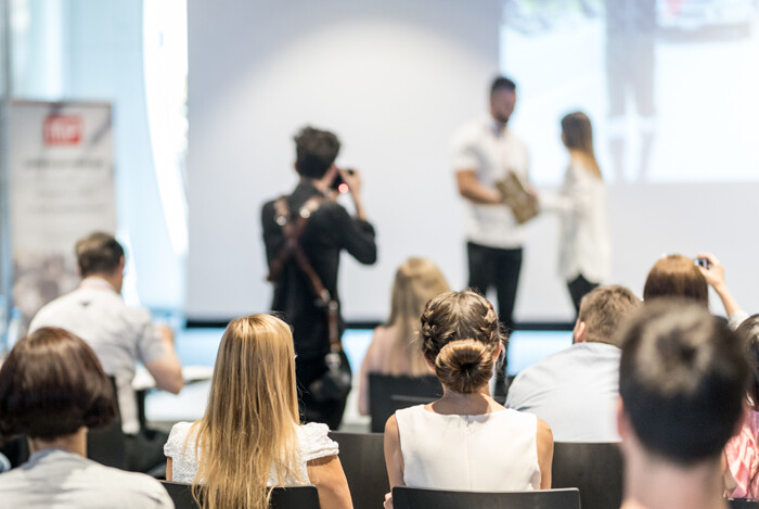 An audience watches an award presentation at a professional event