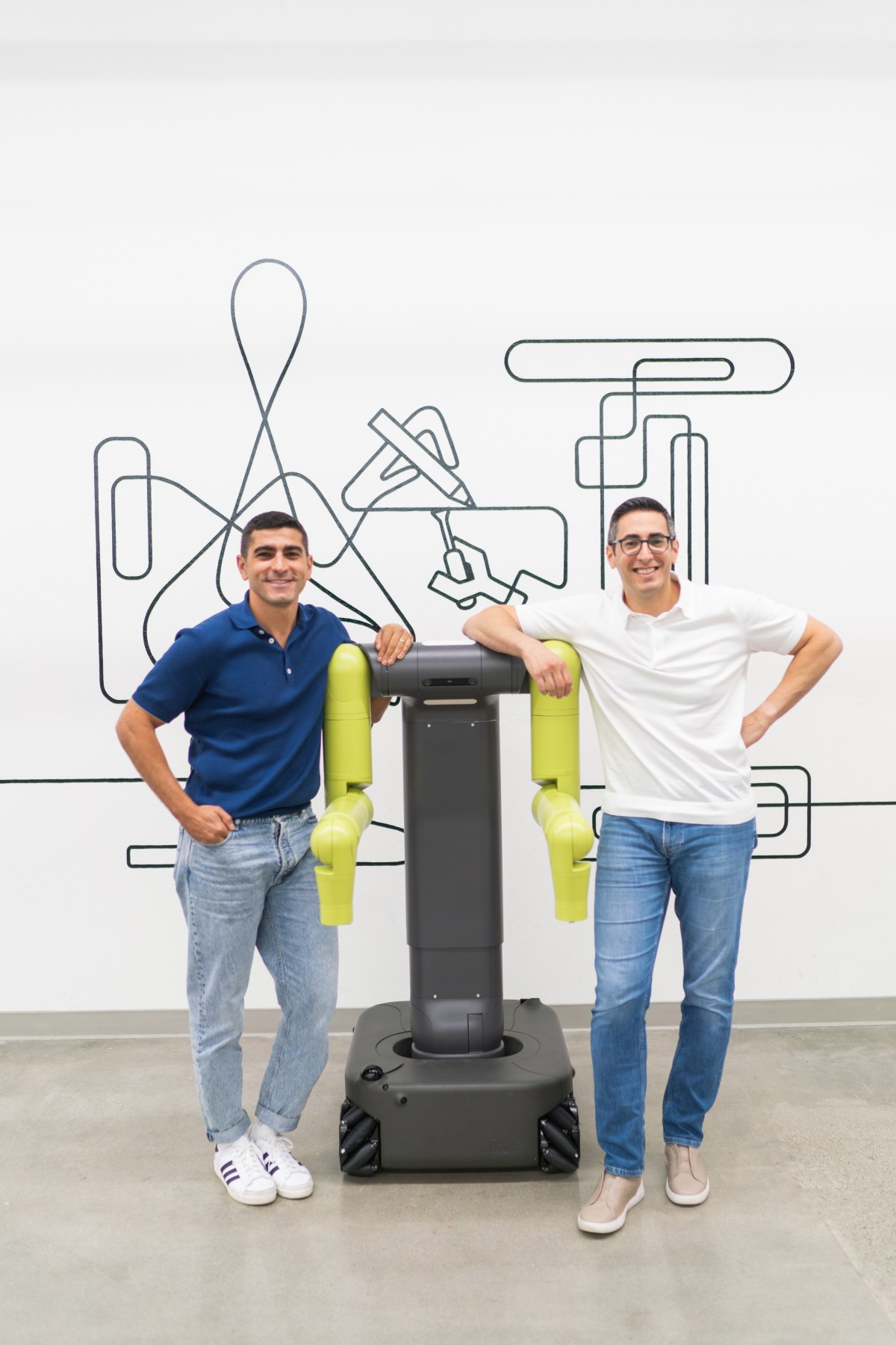 Maven Robotics co-founders Hamza and Khalid Derbas standing beside the company's two-armed wheeled robot