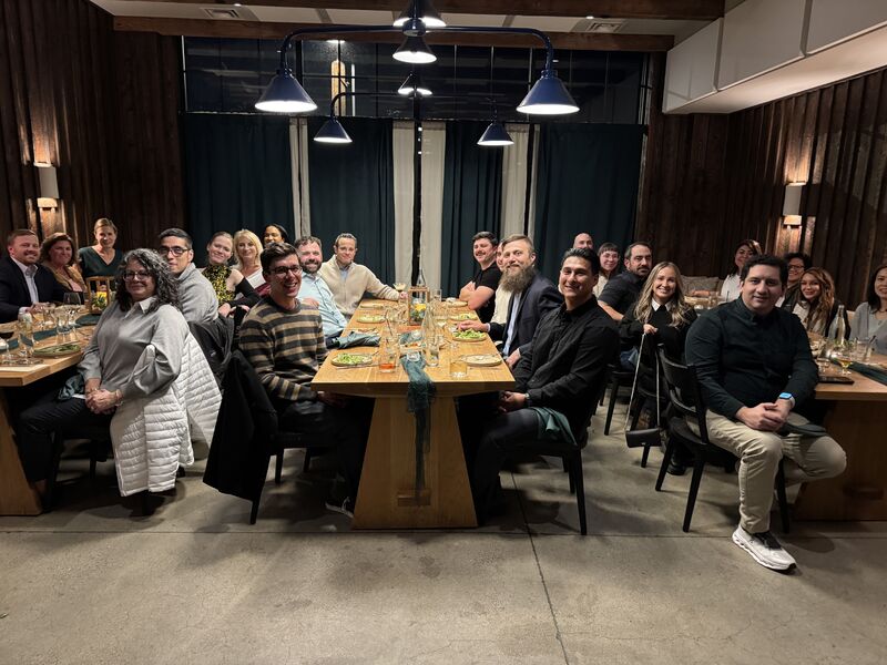 Members of the Anzen team gathered around a long dinner table during a company offsite