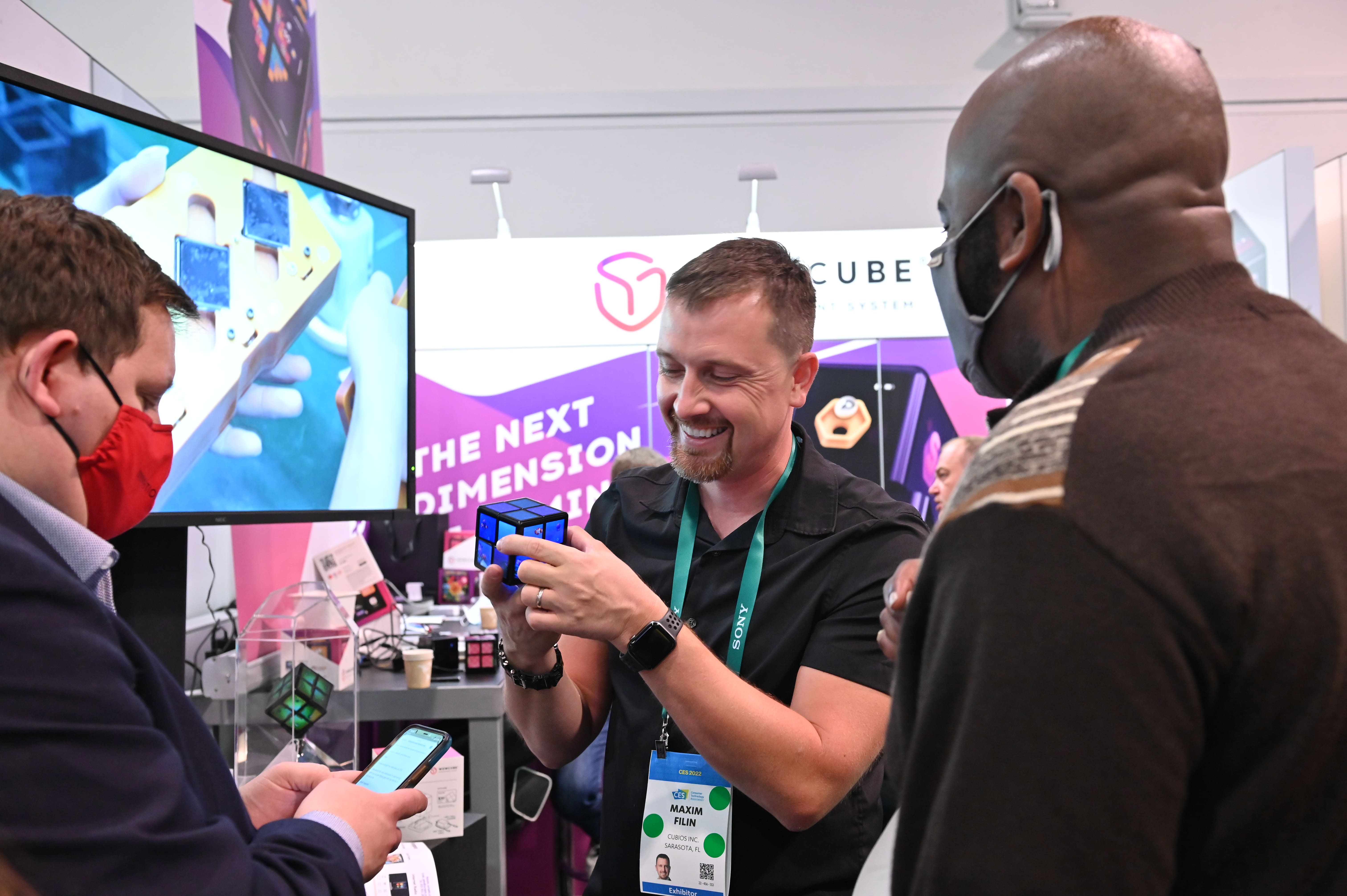Max Filin demonstrating a WOWCube to visitors at an exhibition booth