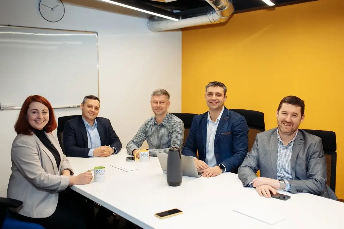 Max Maslii, seated at the right, with four colleagues around a meeting table at Digicode.