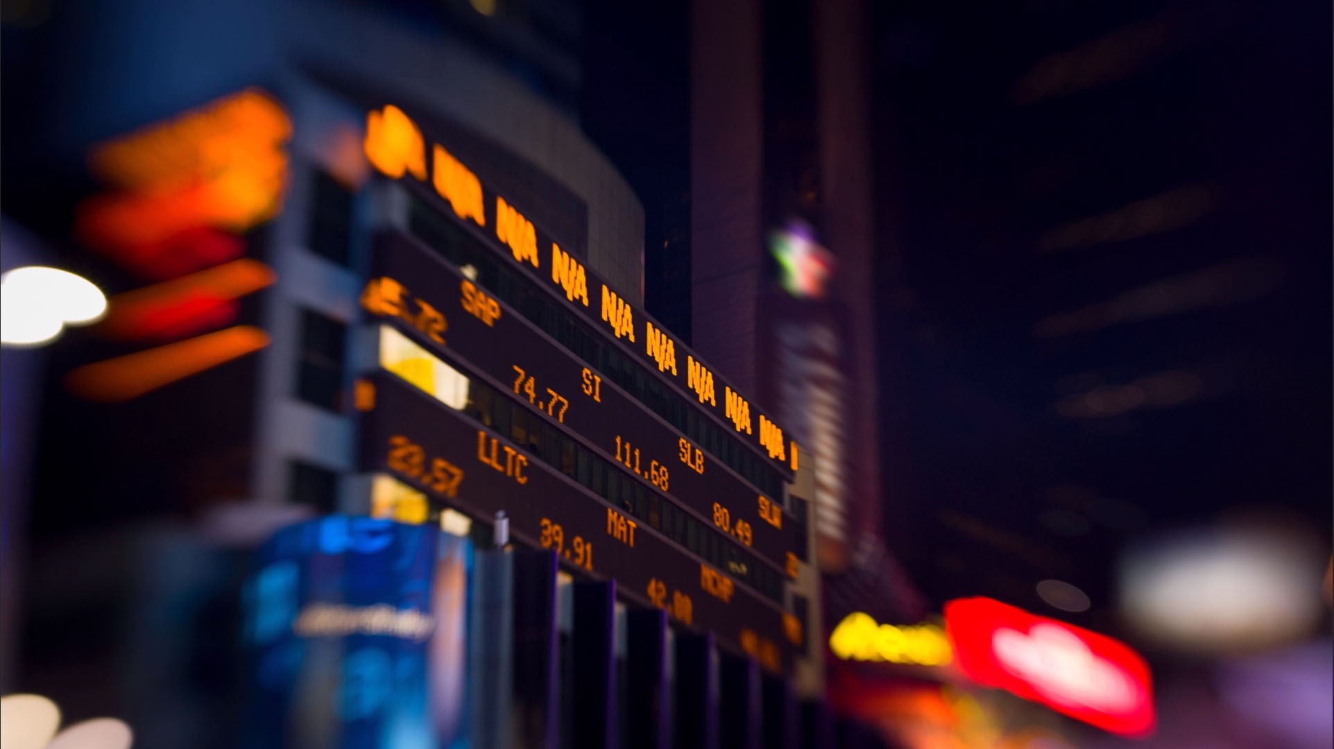 An illuminated stock ticker photographed at night