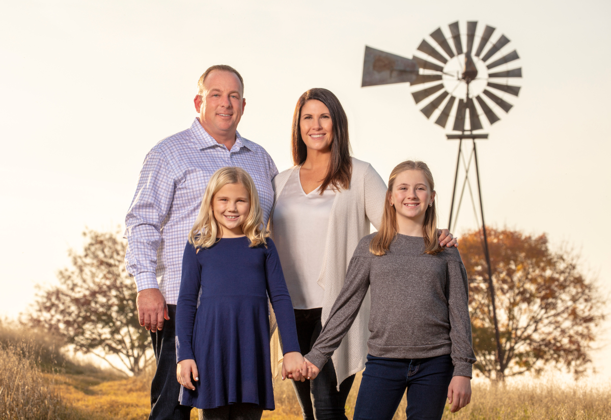 The Critchley family pictured outdoors with a windmill behind them