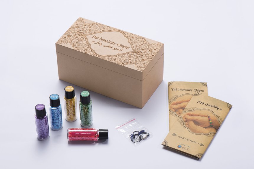 The Immunity Charm kit with color-coded vaccine beads, bracelet parts and an instruction card