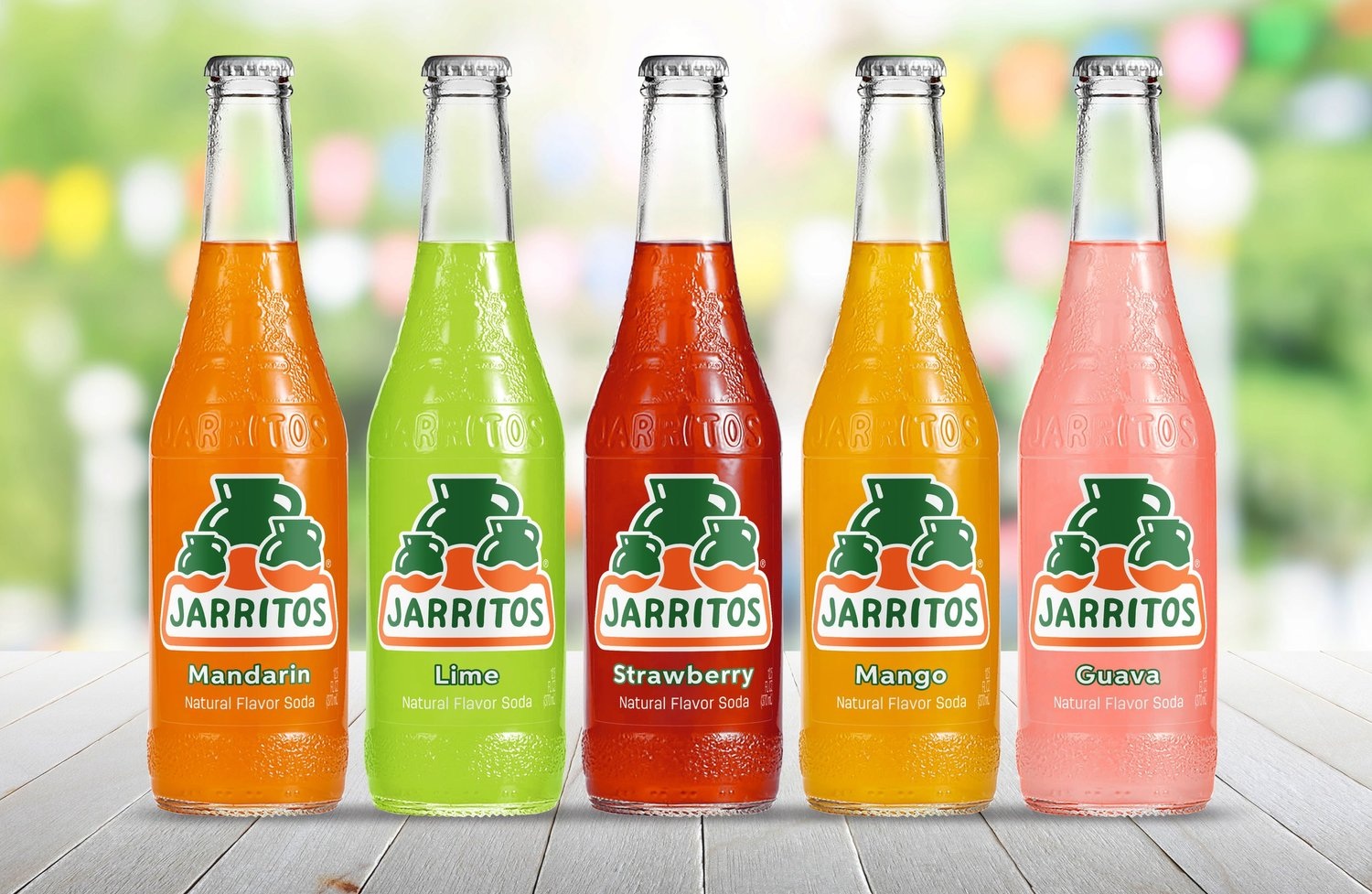 Five Jarritos soda bottles in Mandarin, Lime, Strawberry, Mango and Guava