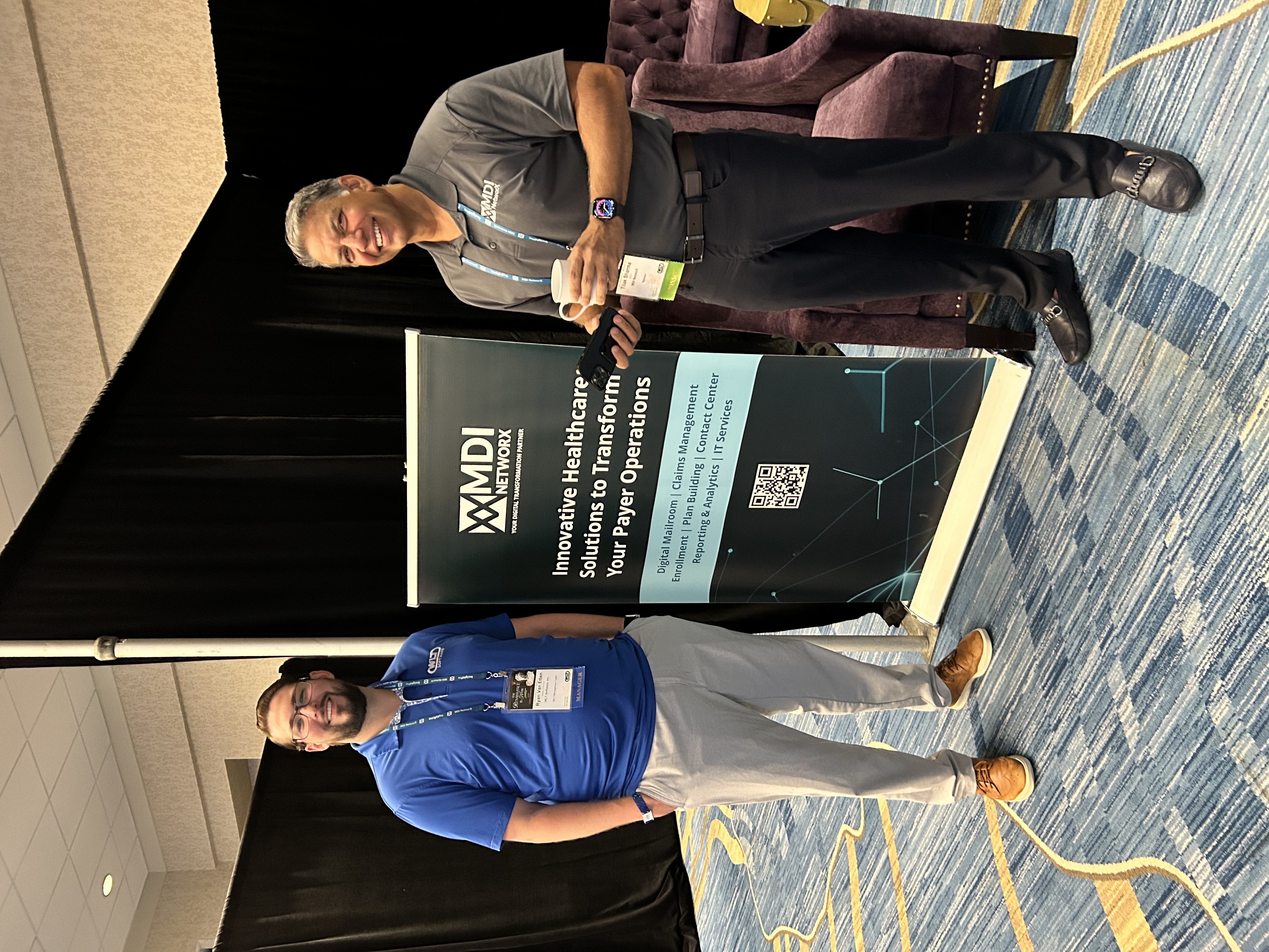 Ryan Van Etten of WLT Software and MDI NetworX CEO Tilak Sharma beside a conference display