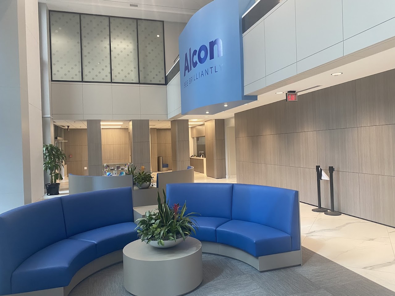 The completed Alcon office lobby, with curved blue seating, pale flooring and paneled walls