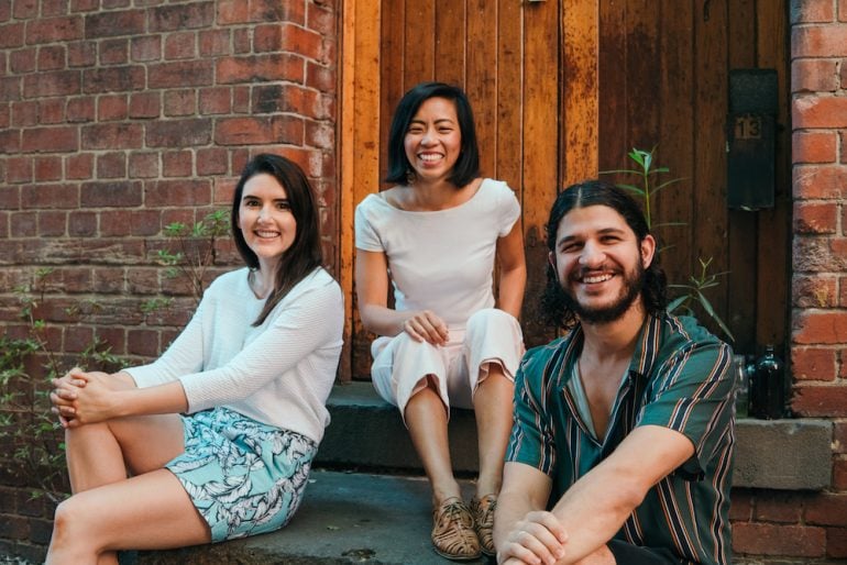 Mr Yum co-founders photographed outside a brick building, with Kim Teo in the centre
