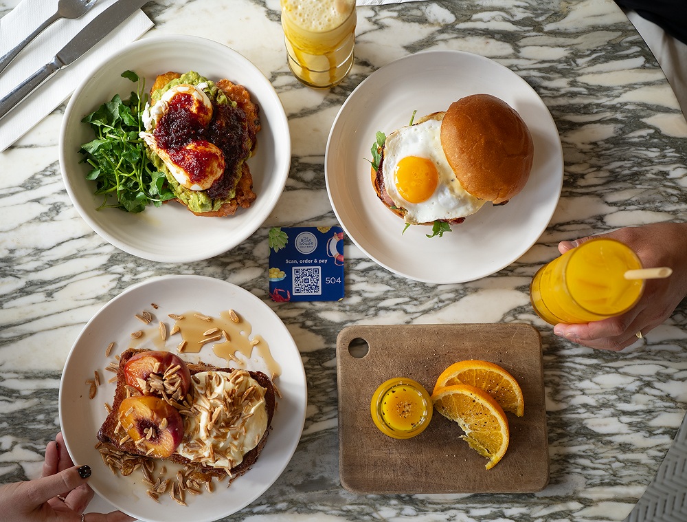 Breakfast dishes surrounding a Boathouse QR ordering card
