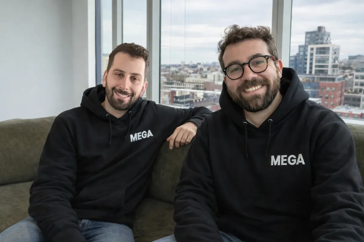 Mega co-founders sitting together in matching black Mega hoodies