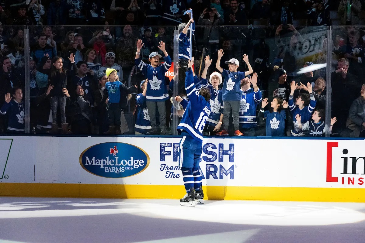 A Toronto Maple Leafs player high-fives young fans through the rink glass during the Next Gen Games campaign