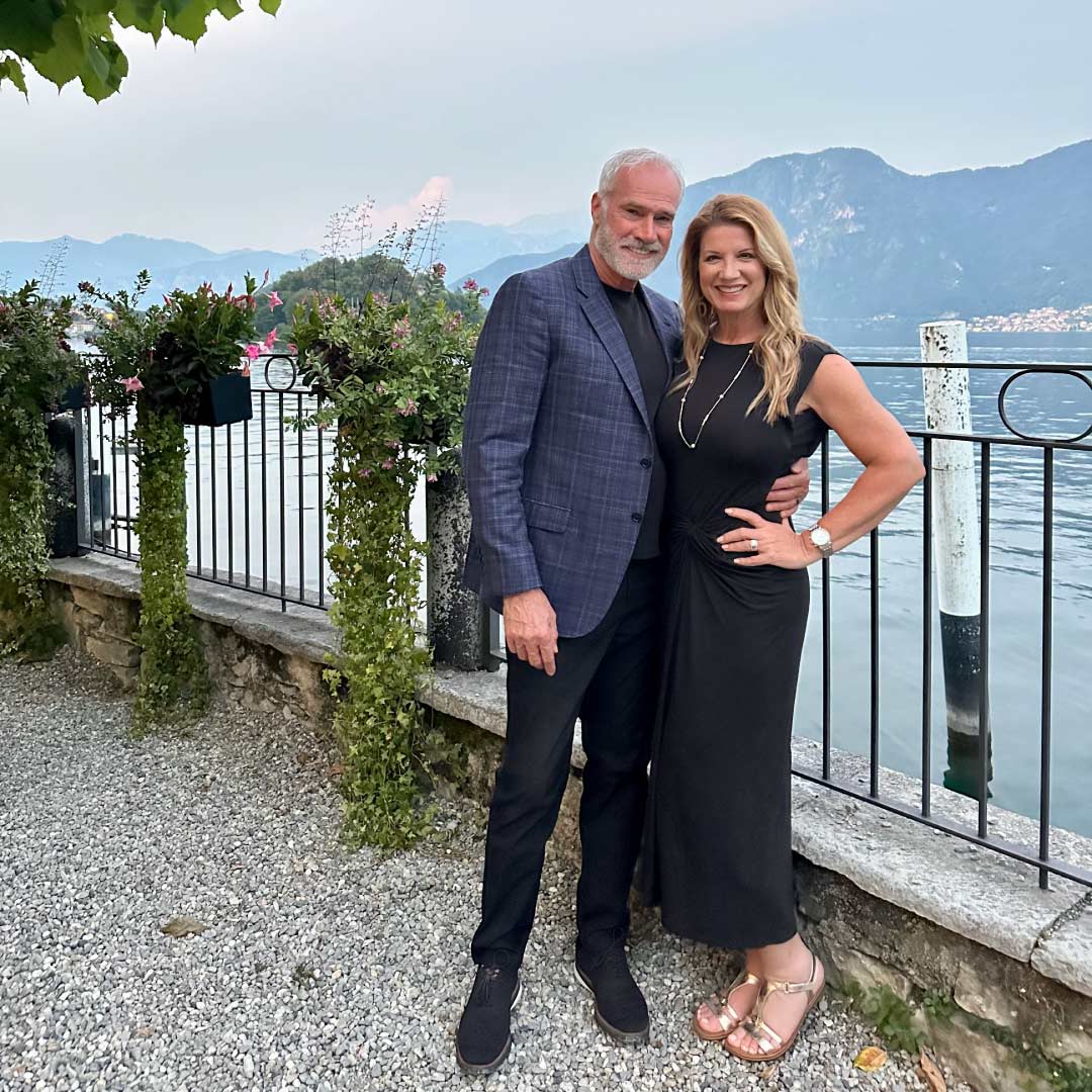 Melea McRae-Hall and her husband standing beside a lake during their travels