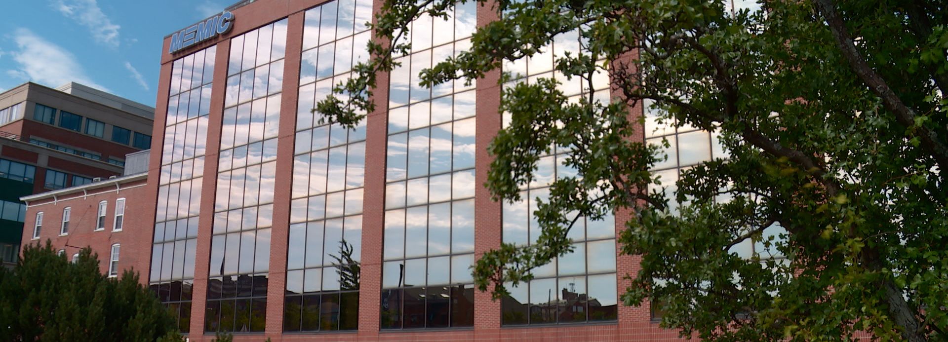 MEMIC’s Portland office building, with brick columns and windows reflecting the sky