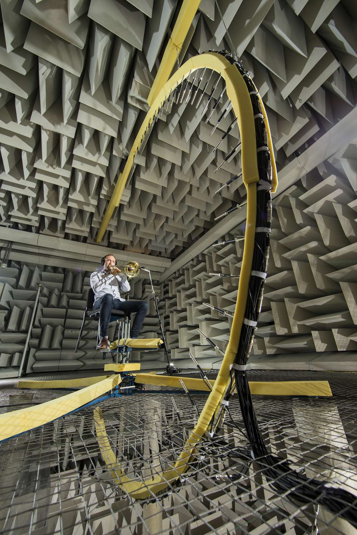 A student playing trombone inside BYU's large anechoic chamber