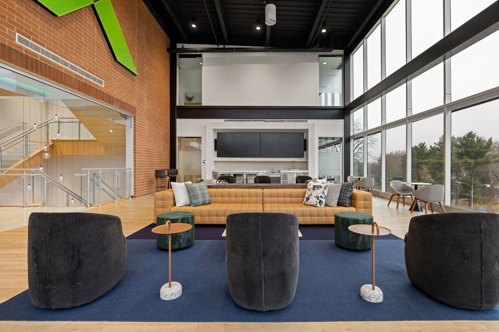 Seating area in Merchants Bank’s headquarters addition, with brick walls, tall windows, and a green Merchants symbol