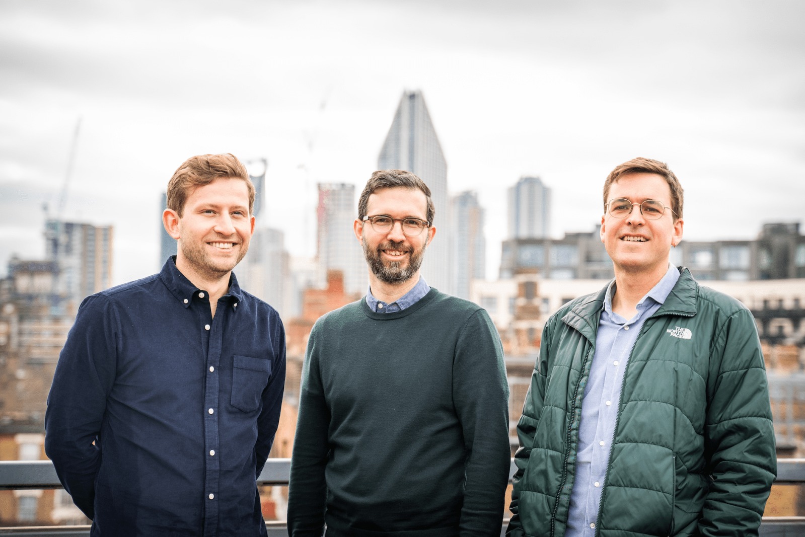 The three Lindus co-founders standing together on a city rooftop