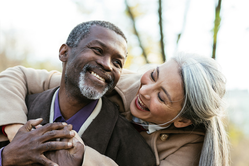 An older couple smiling outdoors in Meridian's public health-plan materials