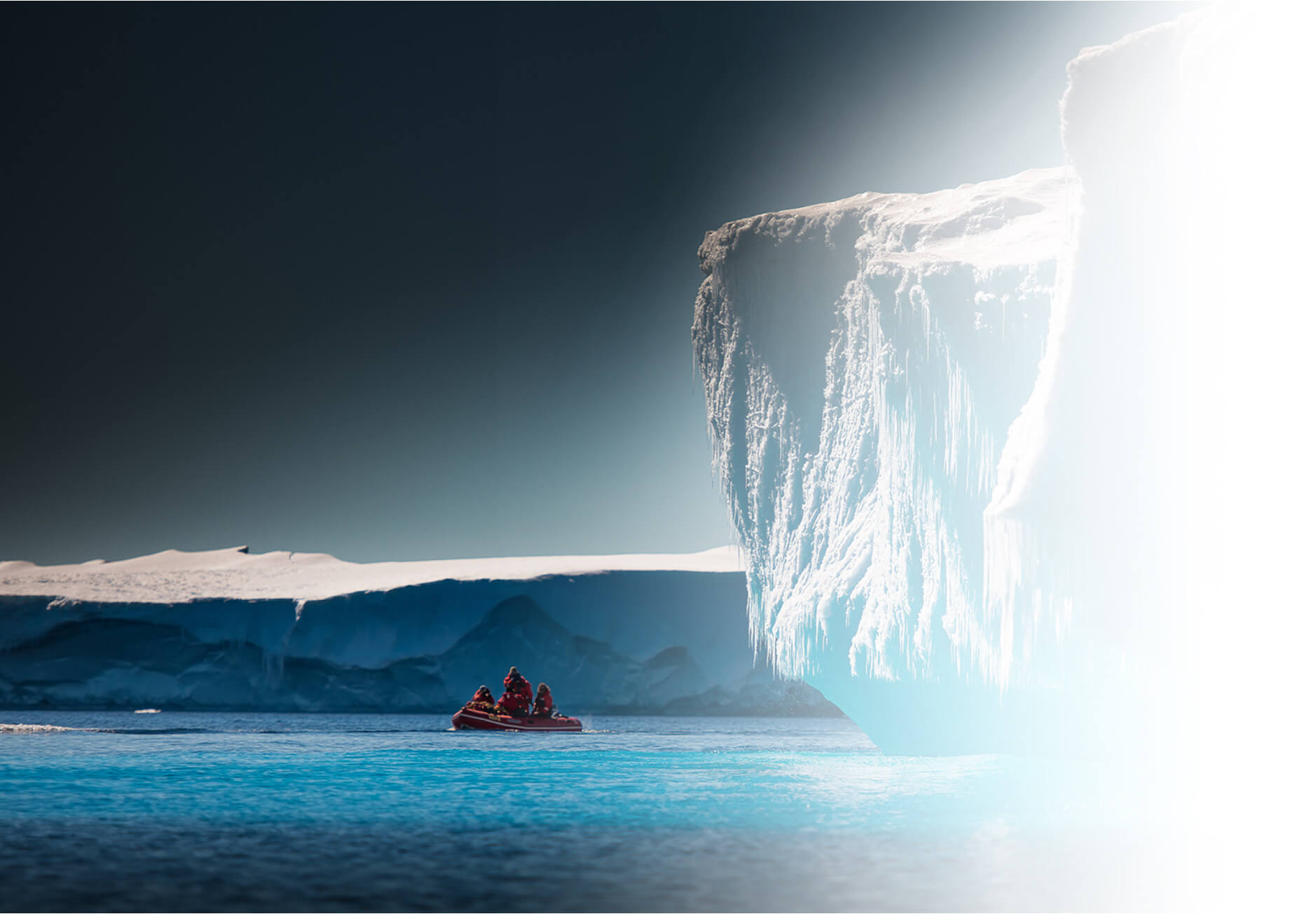 A tiny expedition boat approaching a monumental wall of ice, campaign imagery used in Merit Mile's work for Iridium