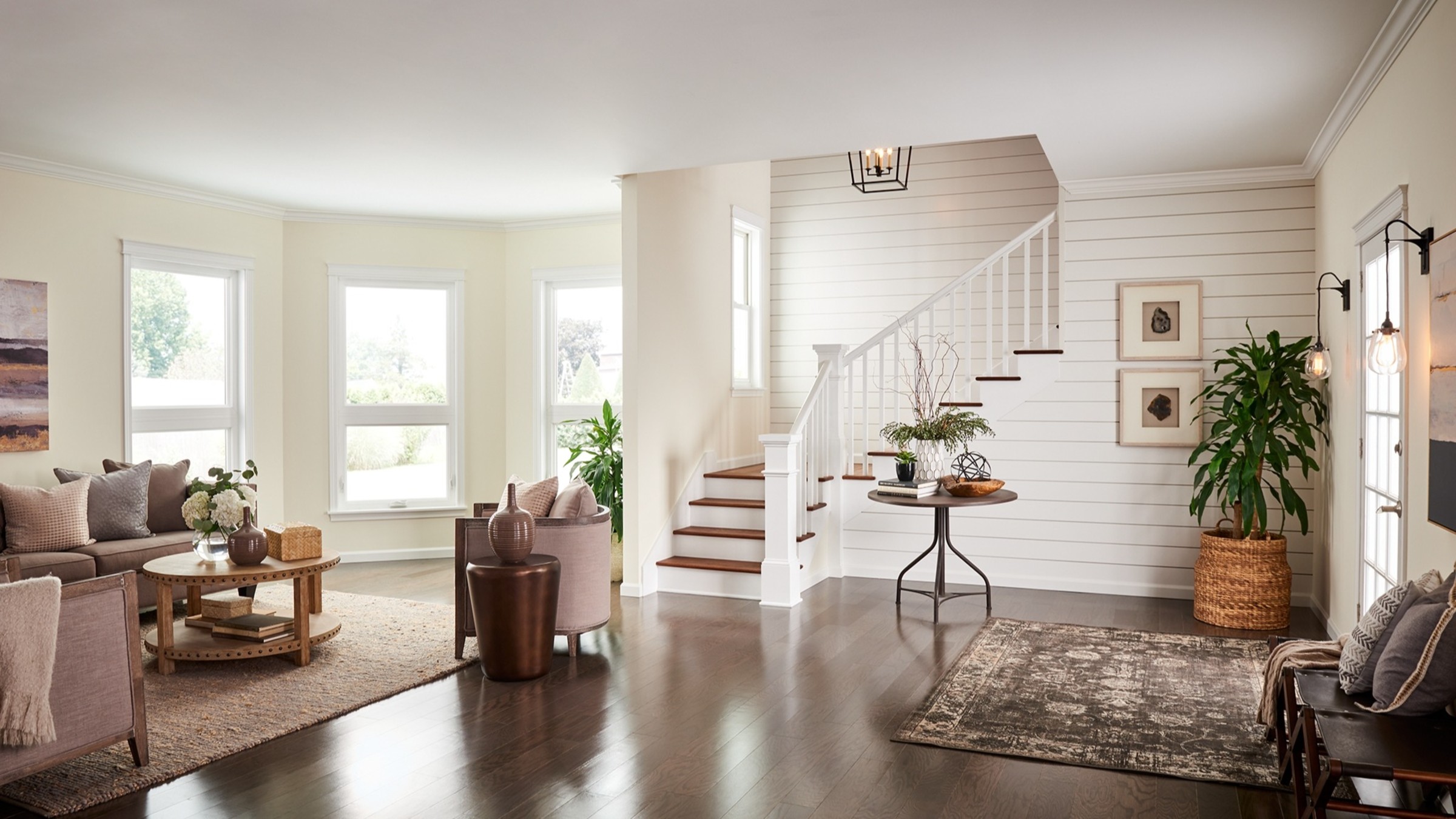 A finished living room with white moulding, shiplap and staircase trim