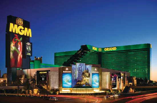 MGM Grand’s green hotel tower and illuminated signs at dusk