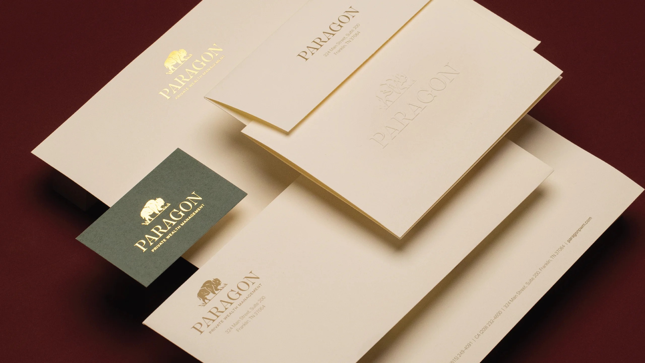 Cream Paragon stationery and a green business card featuring gold branding