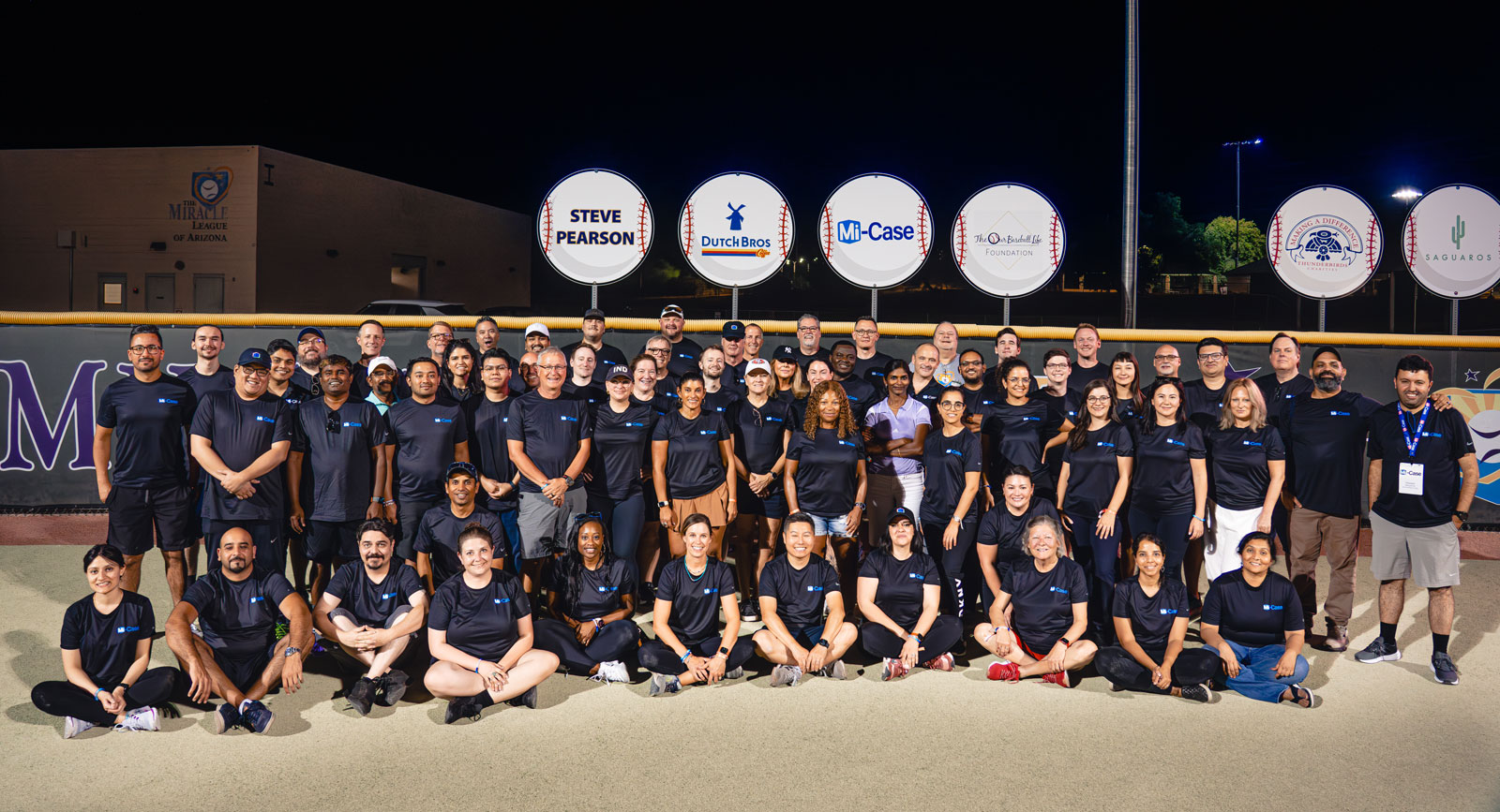 Mi-Case colleagues gathered on a sports field at a company event