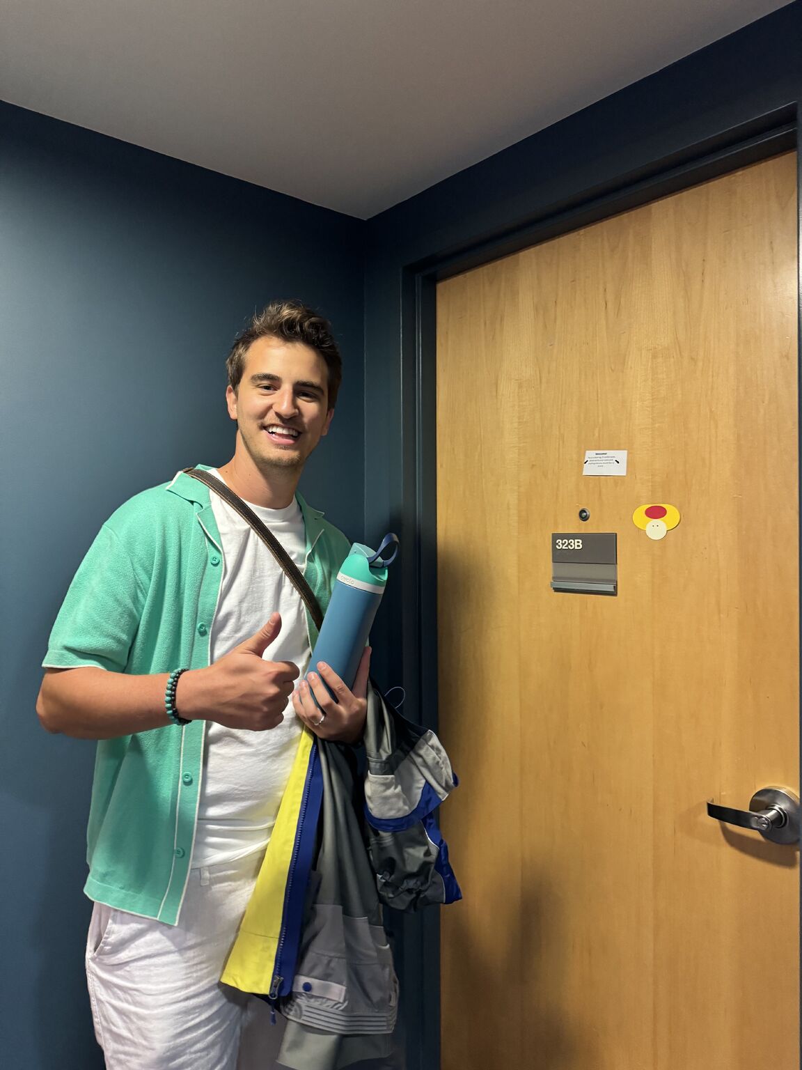 Micah Estis Green on a return visit to Cornell, standing beside a dorm room door