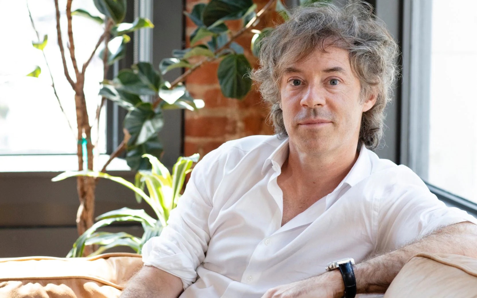 Michael Acton Smith seated by a window in a press photograph