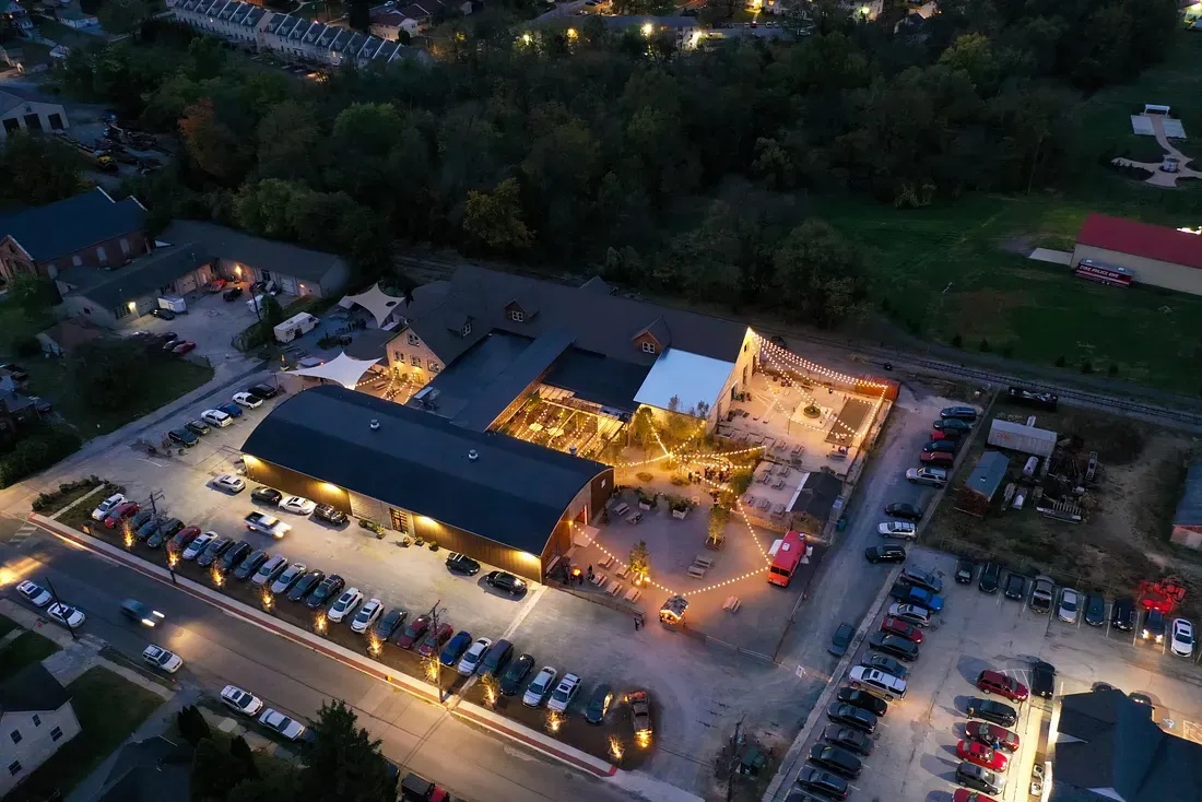 An aerial view of The Creamery in Kennett Square at dusk, with lit courtyards and surrounding streets