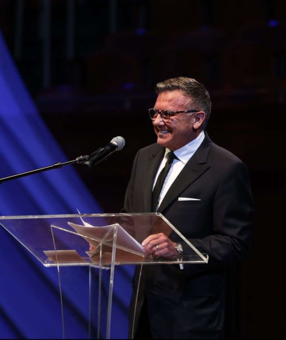 Michael Burcham speaking at a lectern during the 2024 NEXT Awards