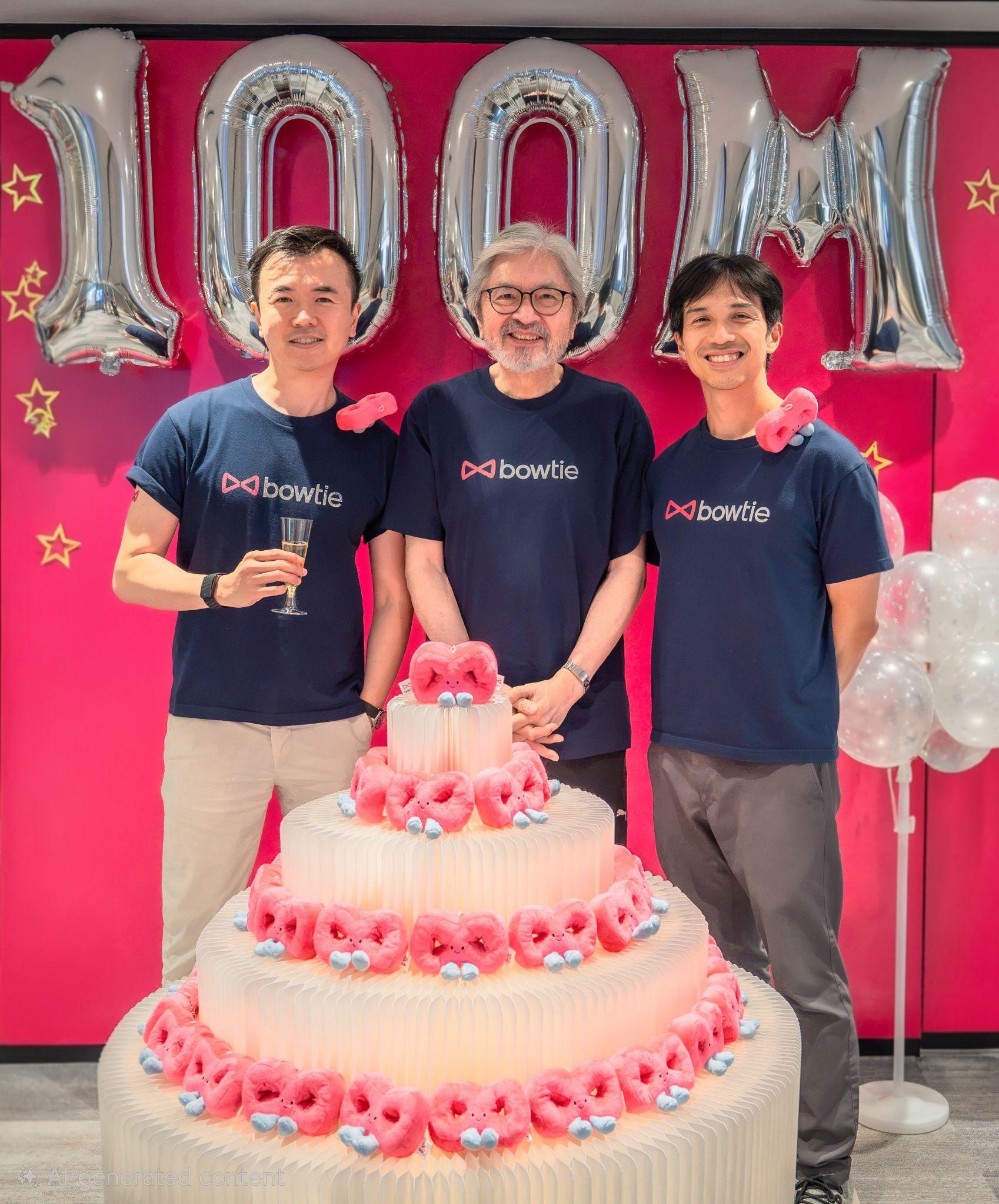 Fred Ngan, John Tsang and Michael Chan standing behind a celebration cake under silver 100M balloons