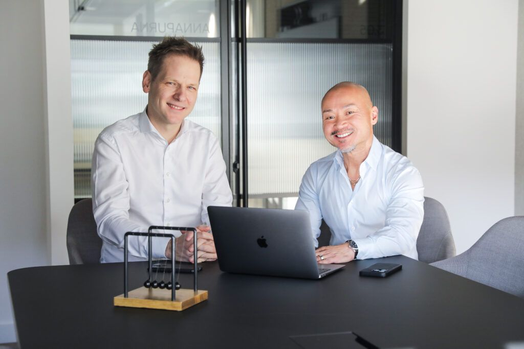 Duco founder Christian Nentwich and Michael Chin seated together at a table in an office