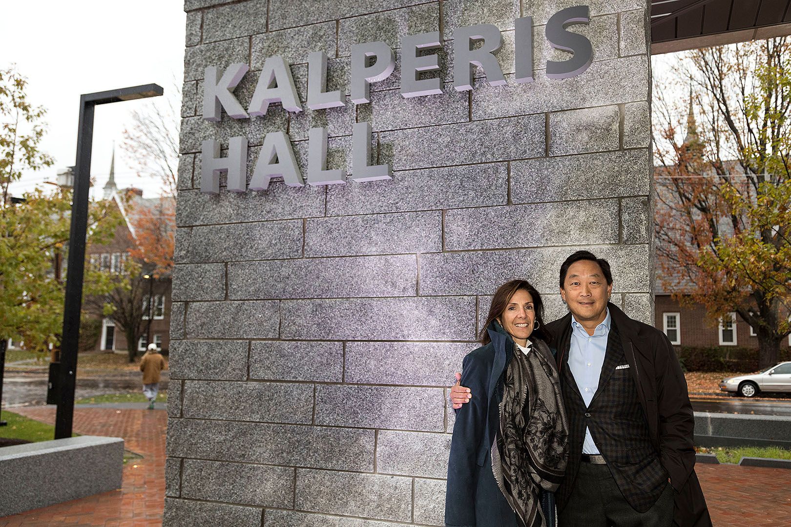 Elizabeth Kalperis Chu and Michael Chu standing outside Kalperis Hall at Bates College in October 2016