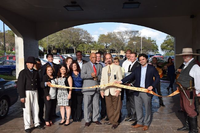 Hotel staff and executives, including Michael Collier, cut a ribbon outside the San Antonio Embassy Suites
