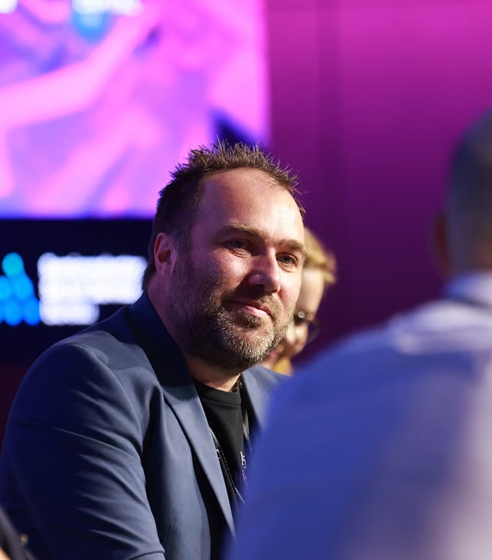 Michael De Nil in conversation at an indoor industry event