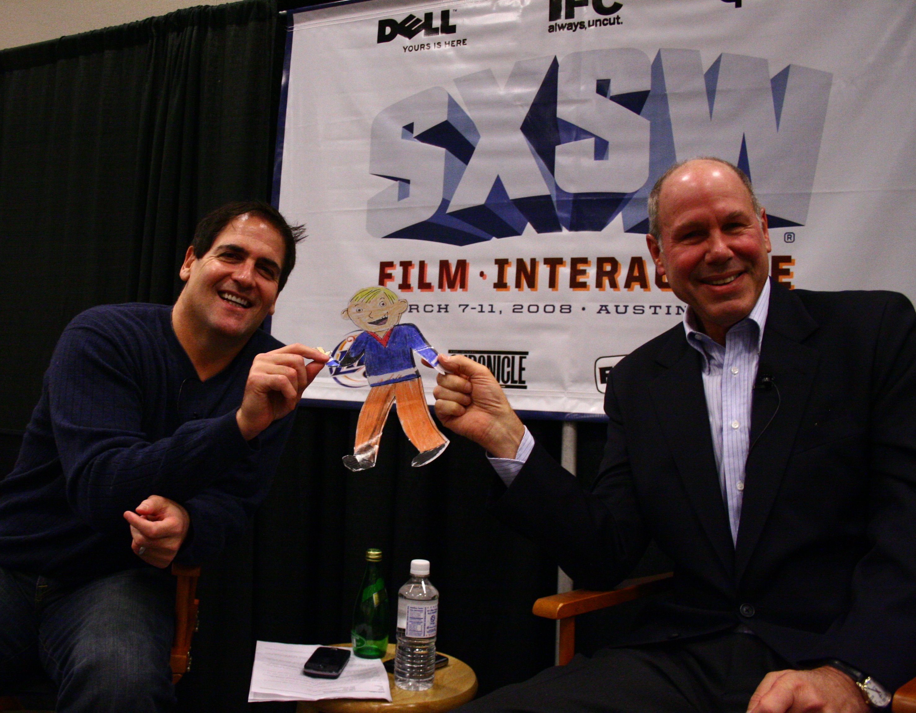 Mark Cuban and Michael Eisner holding a Flat Stanley cutout at SXSW in 2008
