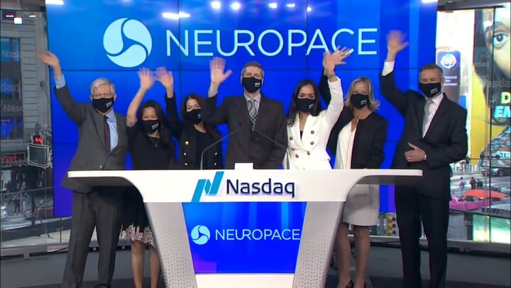 Michael Favet and the NeuroPace team raise their hands at Nasdaq's MarketSite in April 2021
