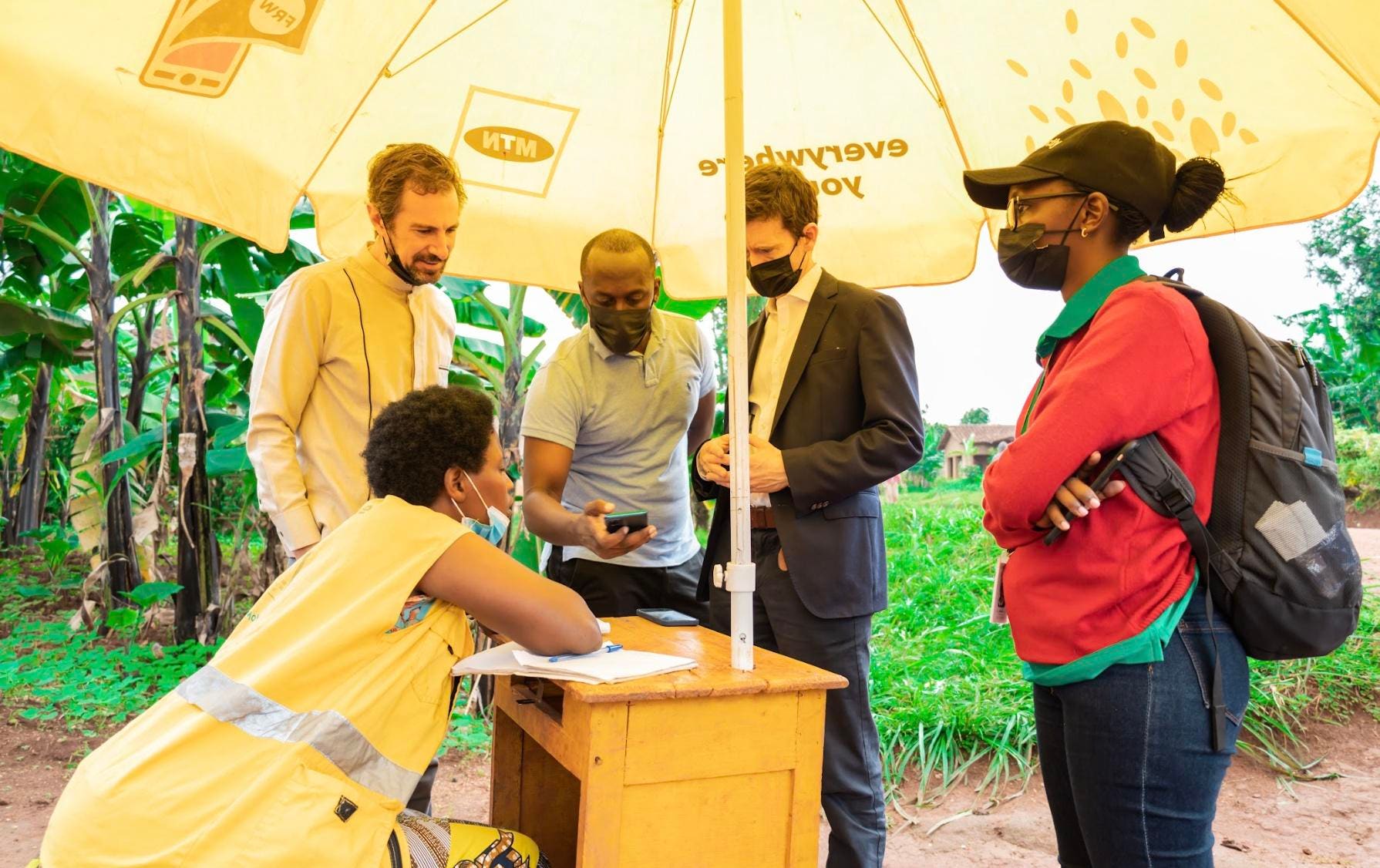 Michael Faye at left with others at a mobile-money agent’s booth in Rwanda