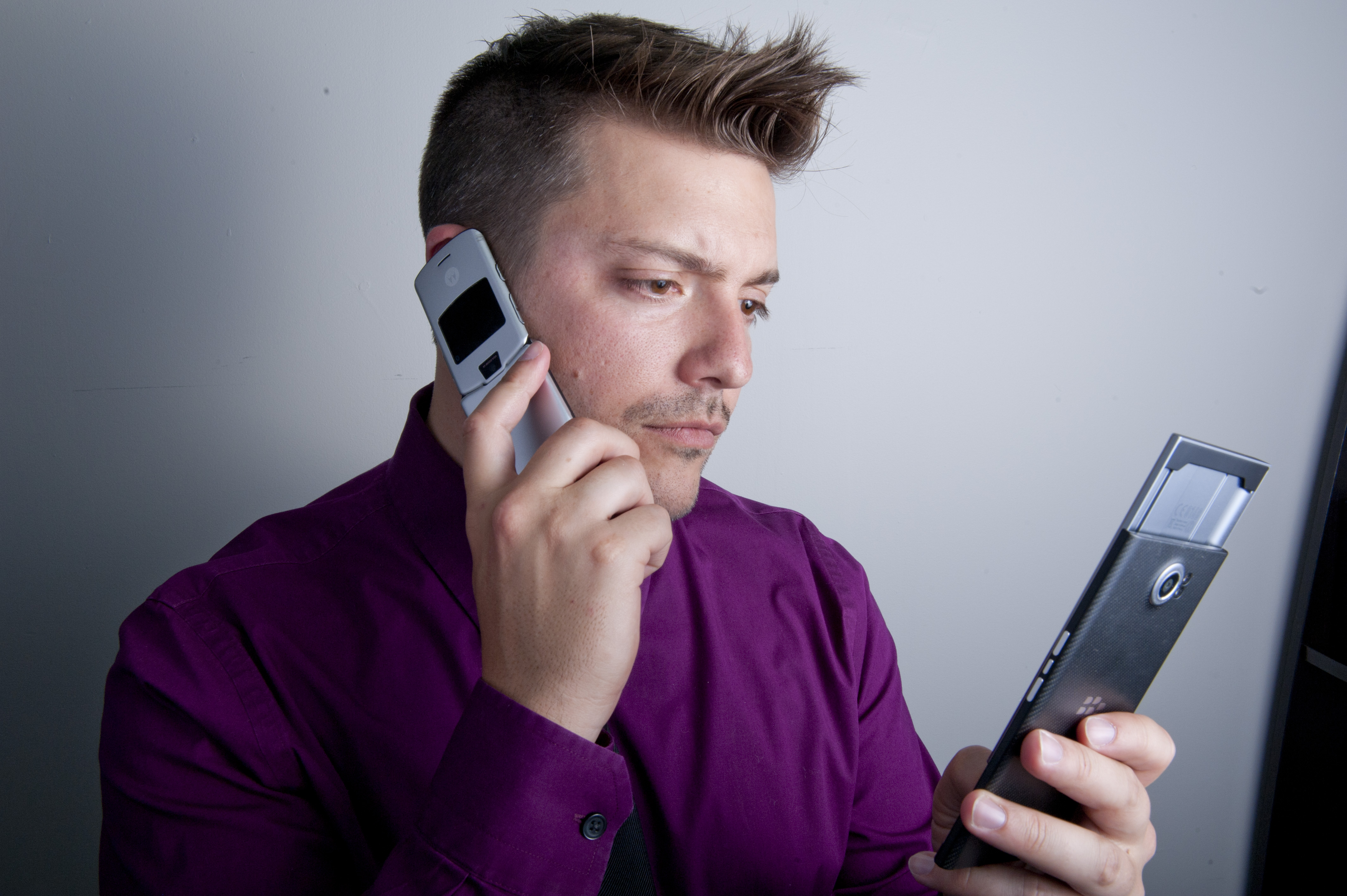 Michael Fisher holding two older mobile phones
