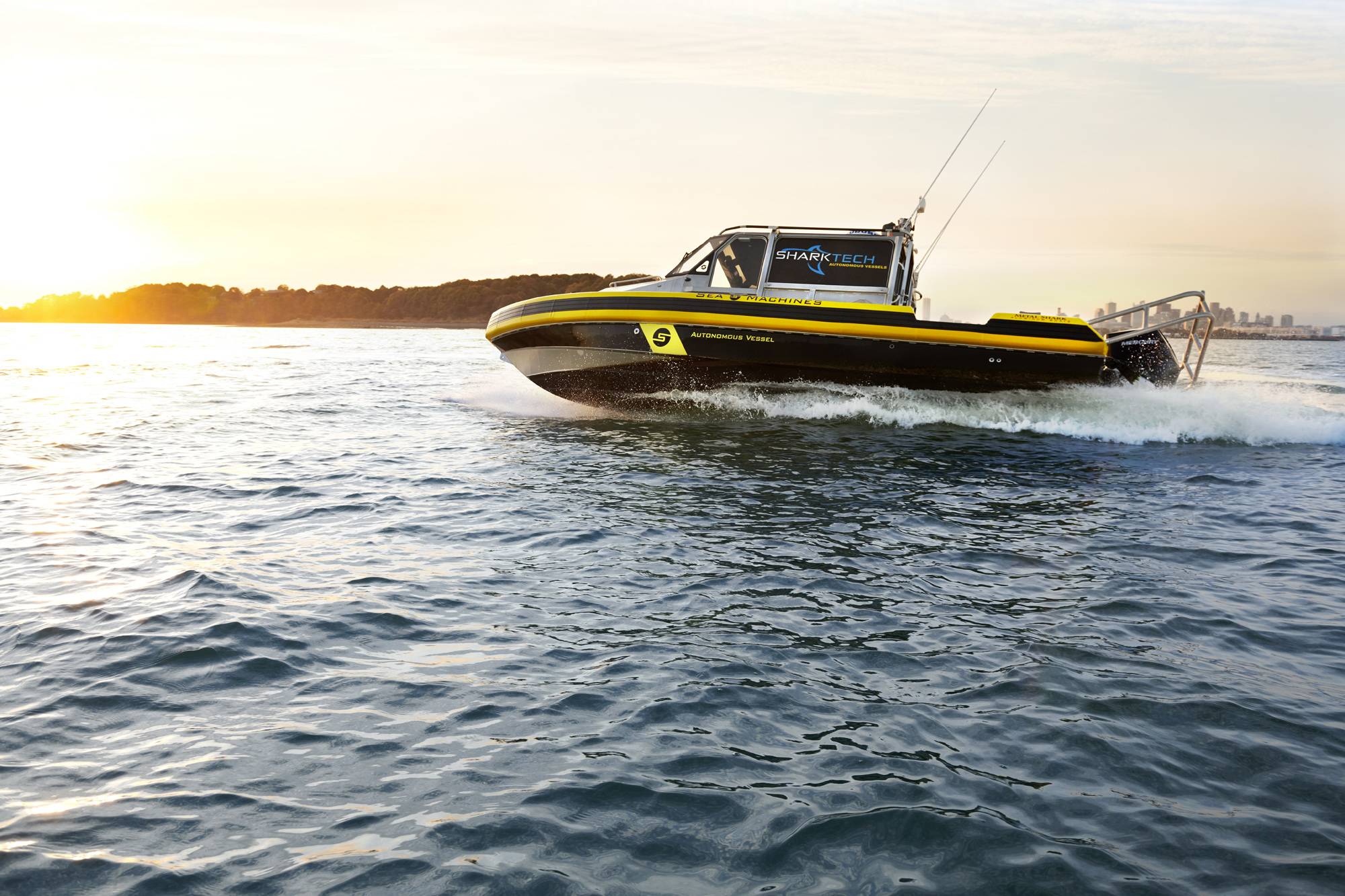 A yellow and black Sea Machines autonomous workboat underway on the water