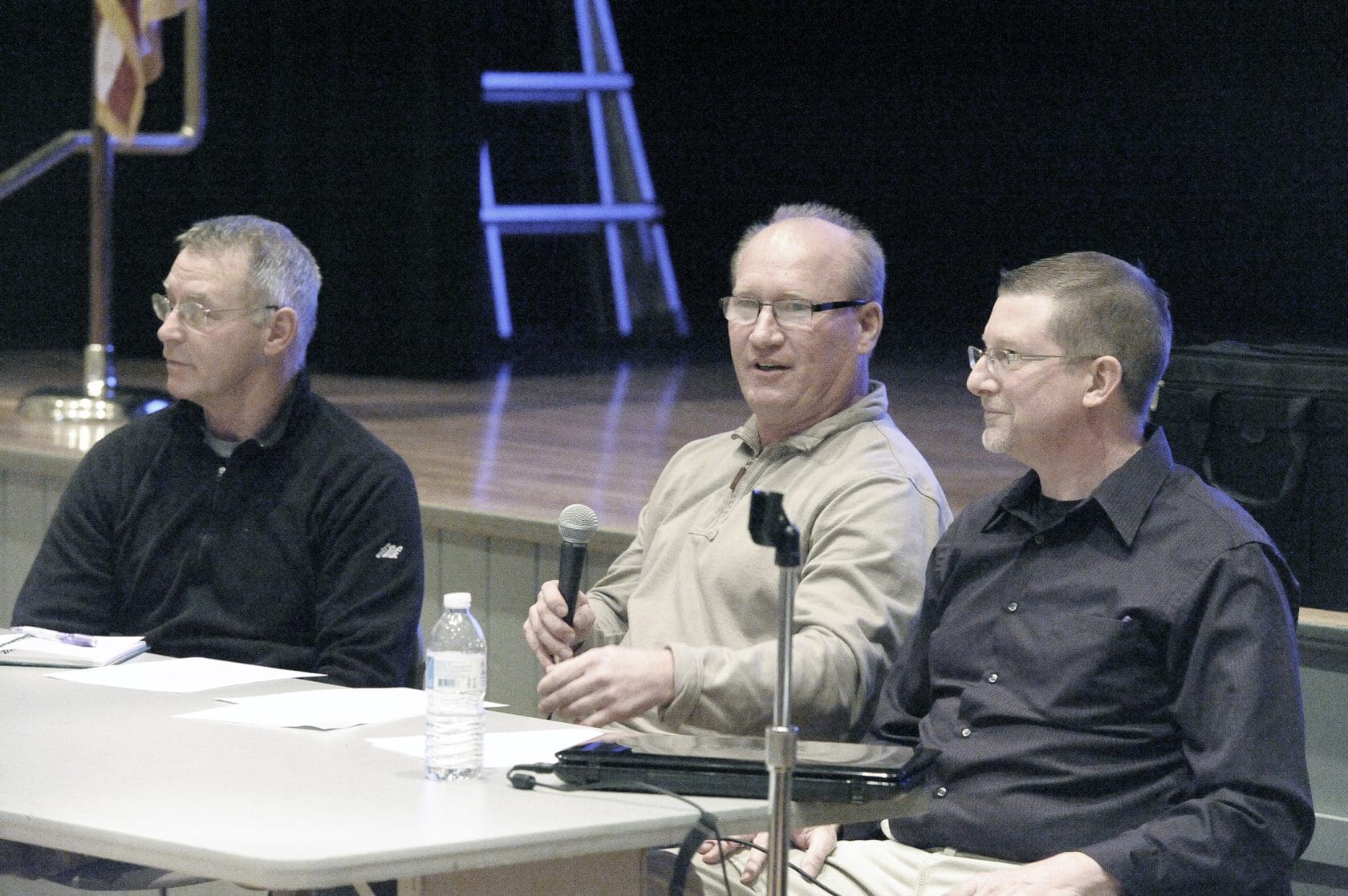 Mike Grondahl, center, holding a microphone between Gary Yelin and Travis Loucks at Southwick Town Hall