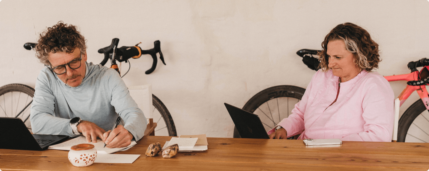 Michael and MacBeth Horvath working at a table with bicycles behind them