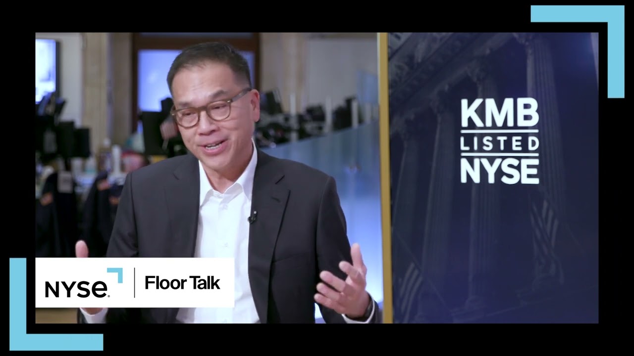Michael Hsu speaking during a NYSE Floor Talk interview beside a Kimberly-Clark listing display