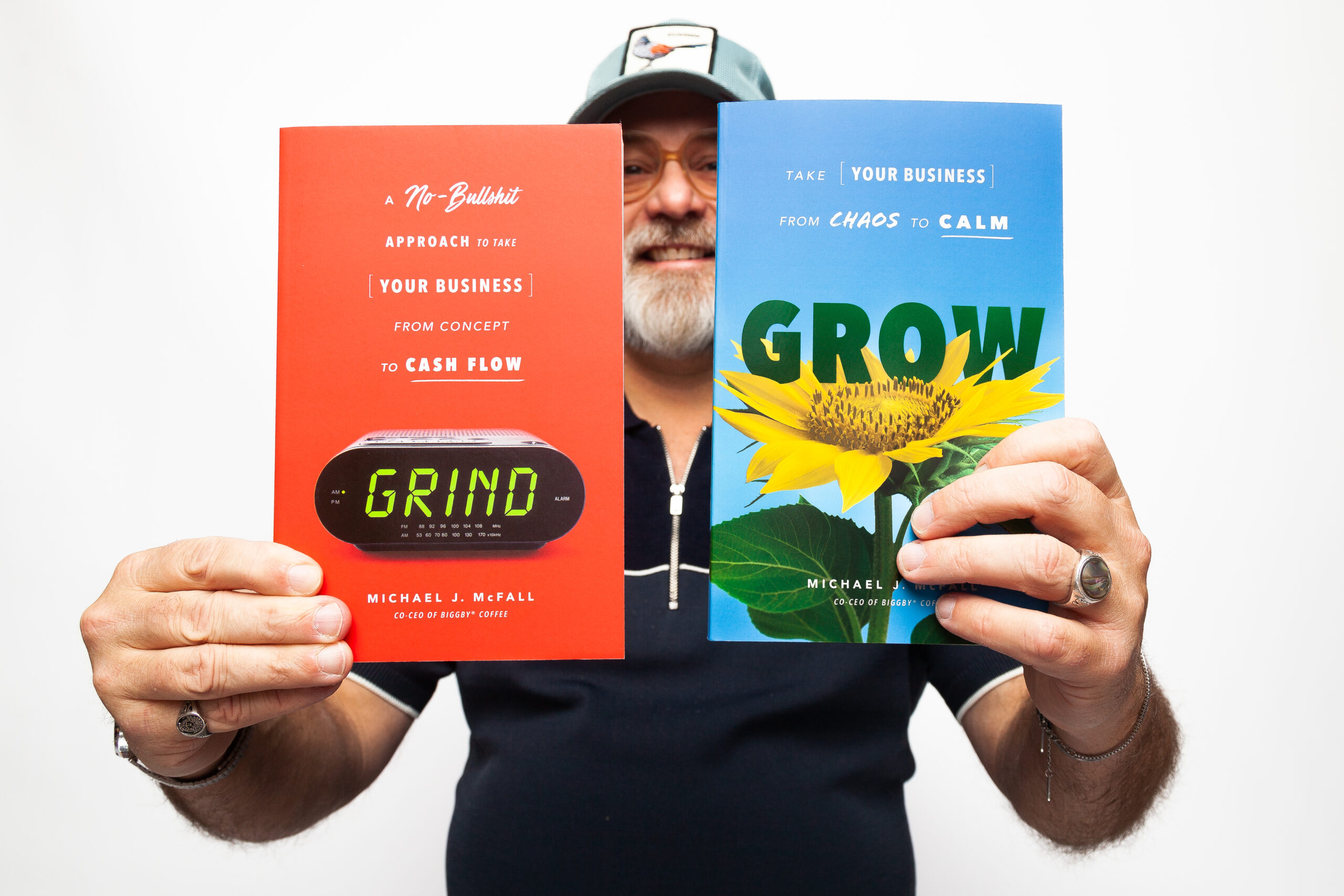 Michael McFall holding copies of his books Grind and Grow