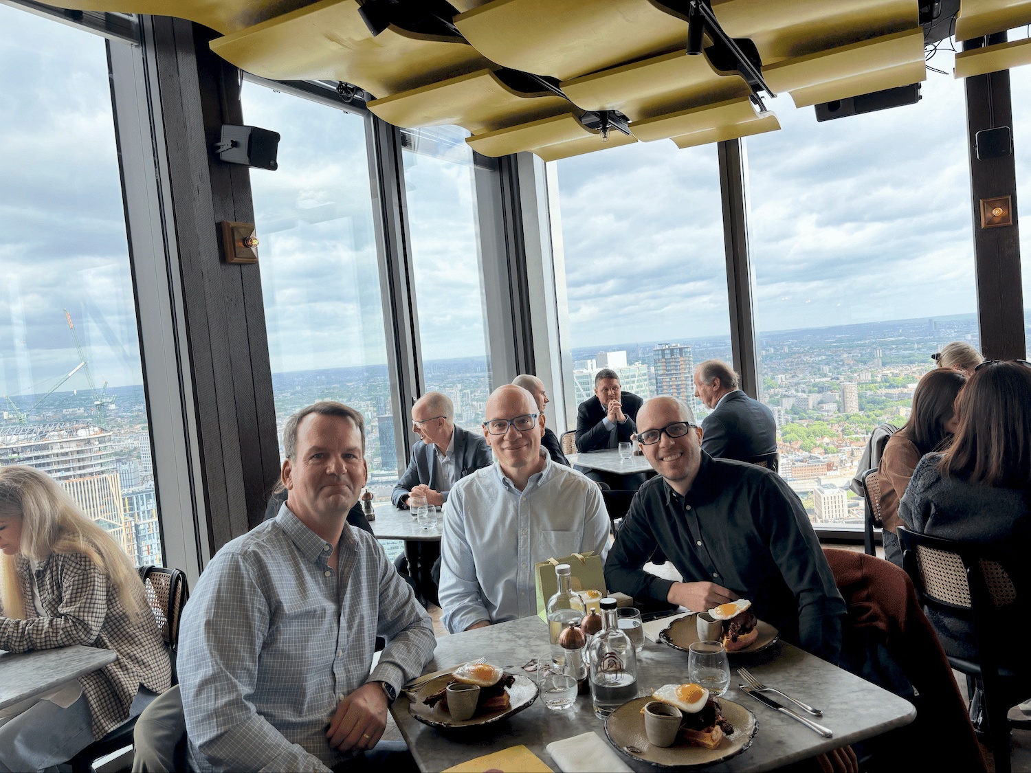 Michael Kriz, Bruno Bitter and Diego Conca seated together at a table overlooking London
